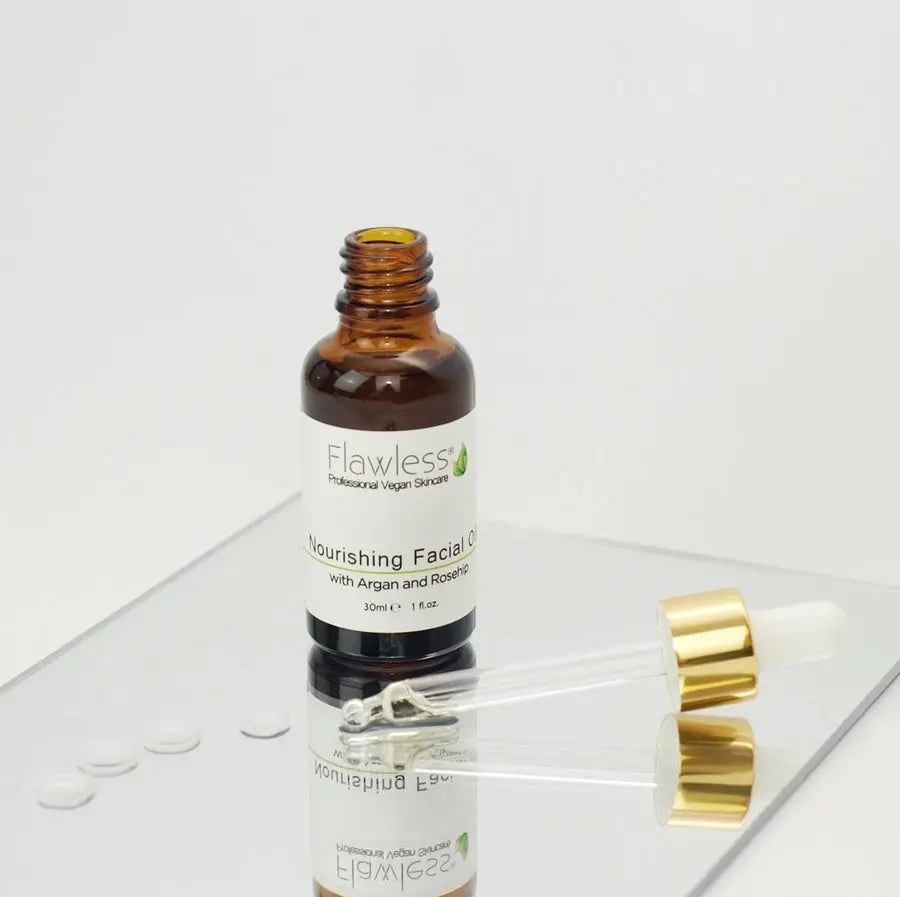Bottle of Flawless nourishing facial oil with a dropper on a white background, brown bottle, lid off, front, liquid dropplets