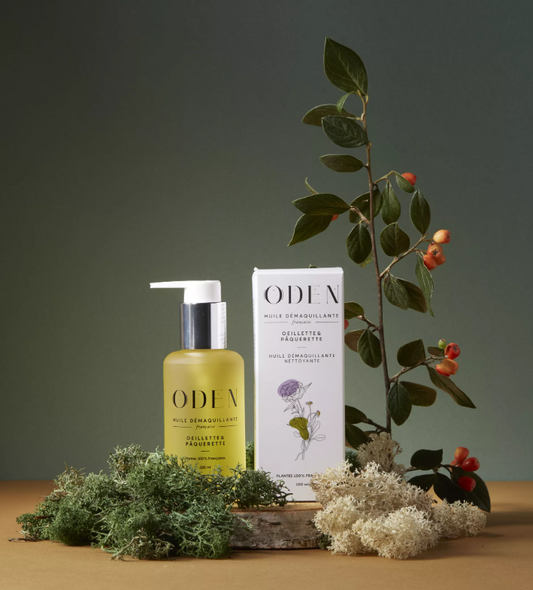 ODEN skincare product with a plant and flowers on a wooden surface
