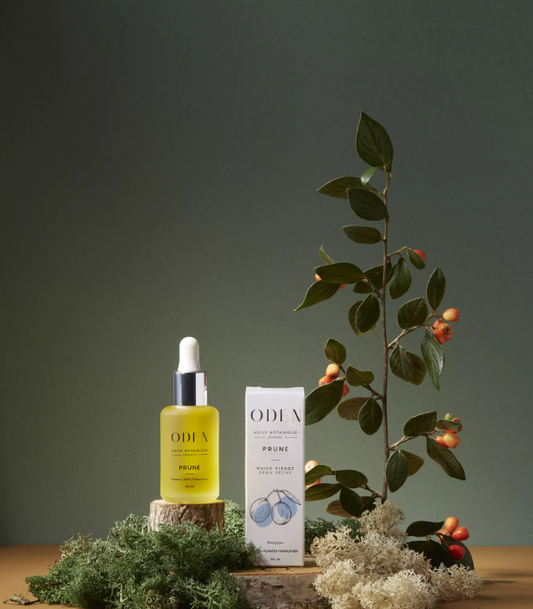ODEN skincare product with packaging and a plant on a wooden surface