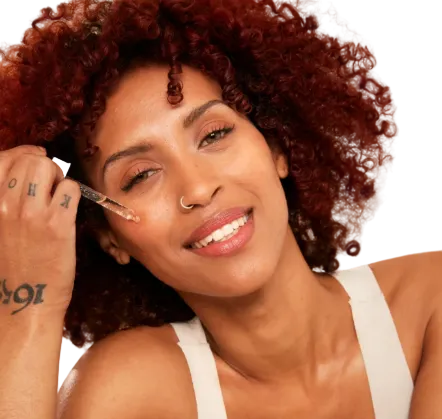 Woman applying face serum with a white background