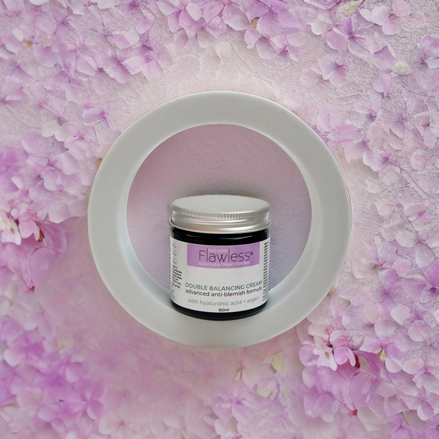 Jar of 'Flawless' cream on a pink floral background