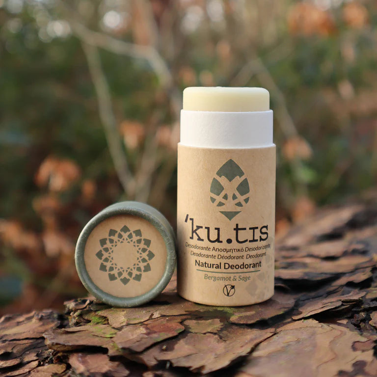 Kutis natural deodorant with a silver award badge on a grassy background, green lid off, front. 