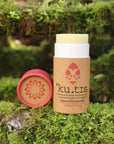 Kutis Grapefruit & Rose Natural Beeswax Deodorant, on grassy background, lid off, front view