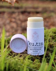 kutis Unscented Bicarb Free Vegan Natural Deodorant, front view, lid off, pink cap on grassy background