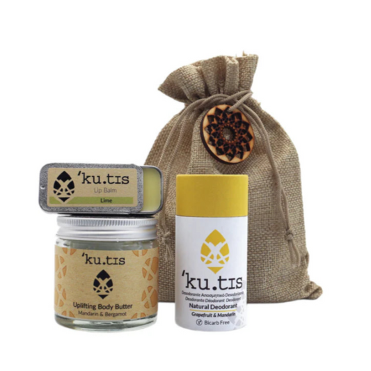 Kutis skincare products including lip balm, body butter, and deodorant with a drawstring bag on a white background.