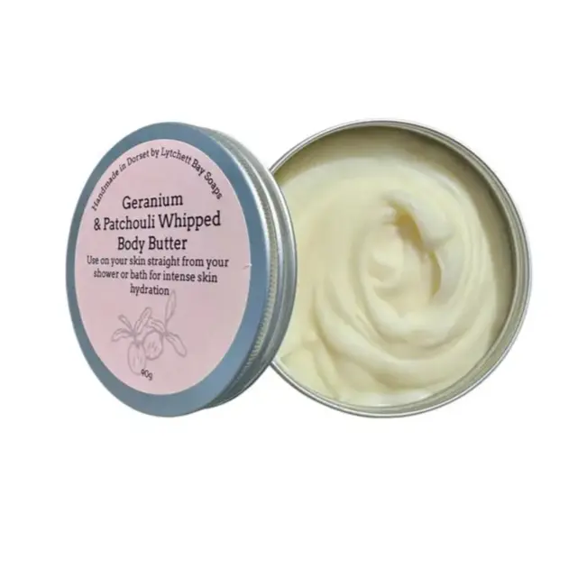 Open tin of Geranium & Patchouli Whipped Body Butter with visible cream inside on a white background
