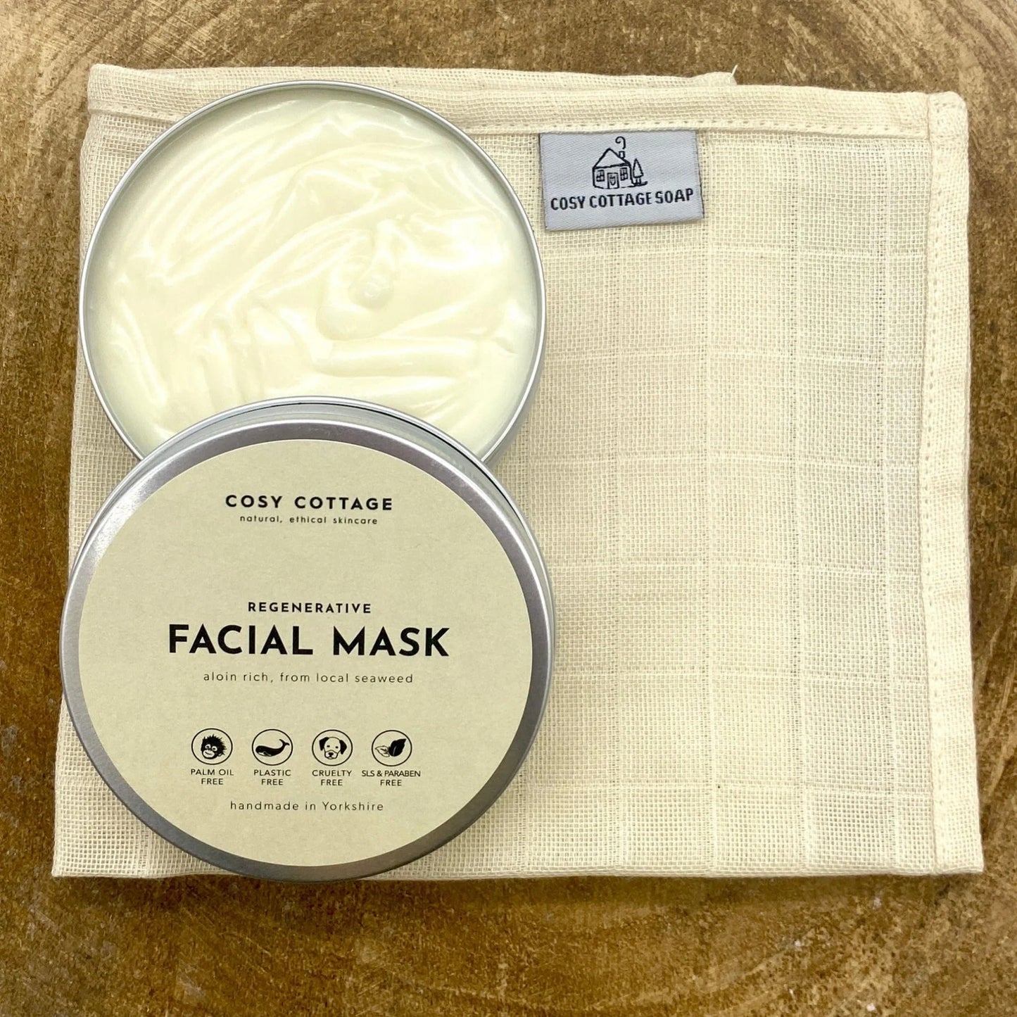 Cosy Cottage facial mask tin on a beige cloth with visible branding